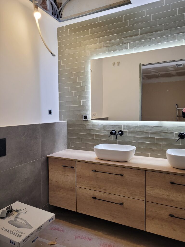 Baño con dos lavabos y mueble de madera reformado