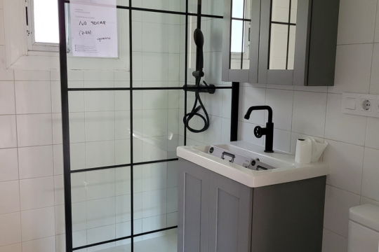 Baño de color gris con grifería negro reformado por Aod Arquitectura